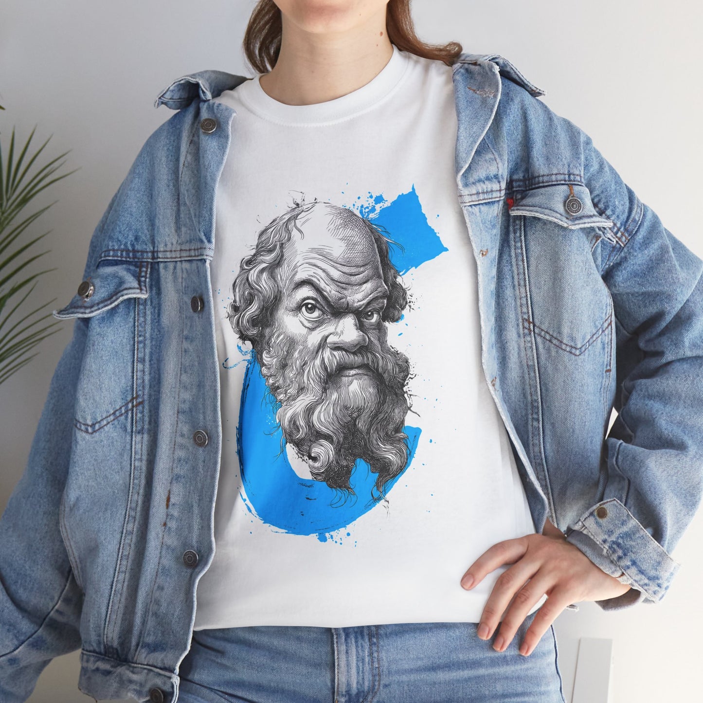 Person wearing a white t-shirt with a graphic design of a bearded man and a blue circle, paired with a denim jacket.