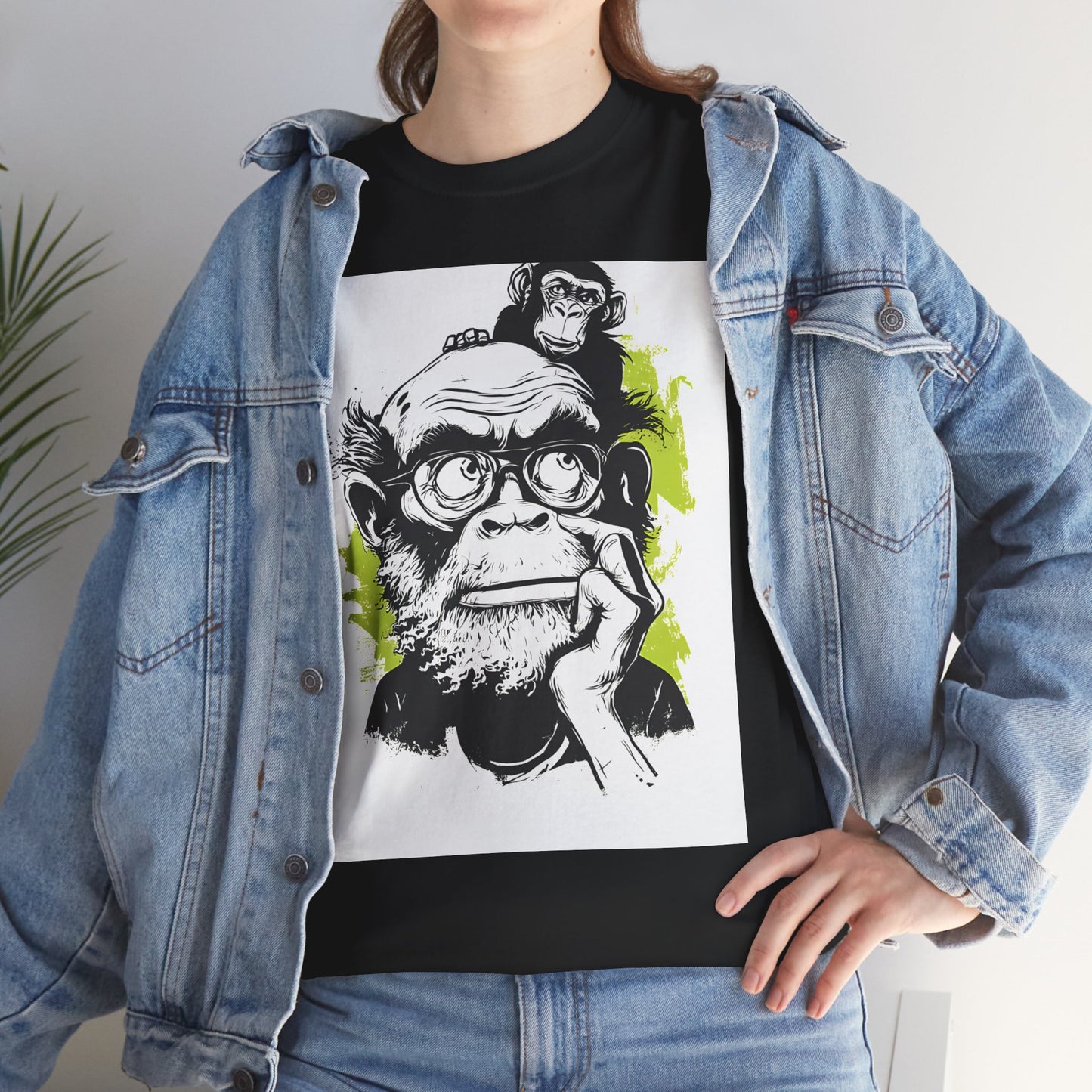 Person wearing a black t-shirt with a graphic design of a monkey wearing glasses, paired with a denim jacket.