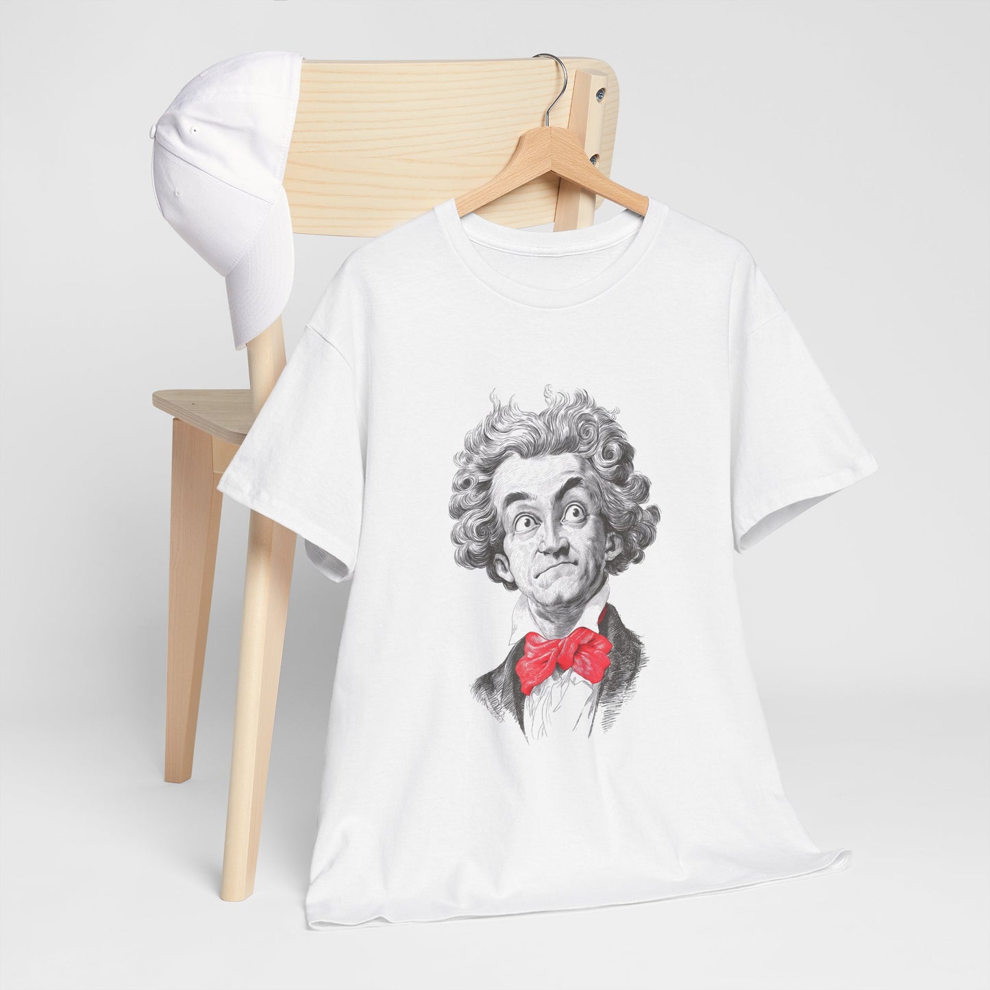 White t-shirt with a graphic design of a person wearing a red bow tie on a wooden chair.