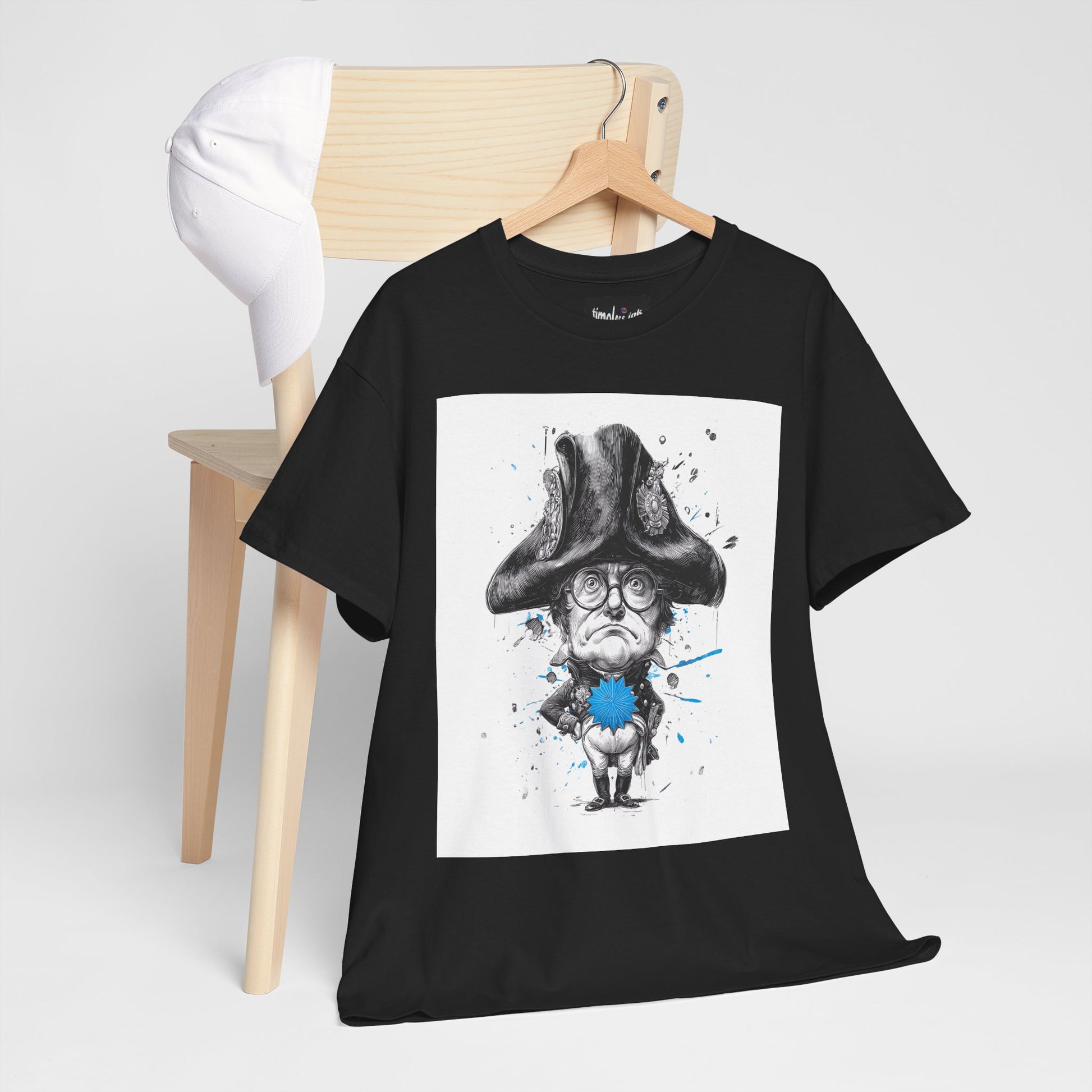 Black t-shirt with a graphic design of a person in a hat and glasses on a wooden hanger against a white background.