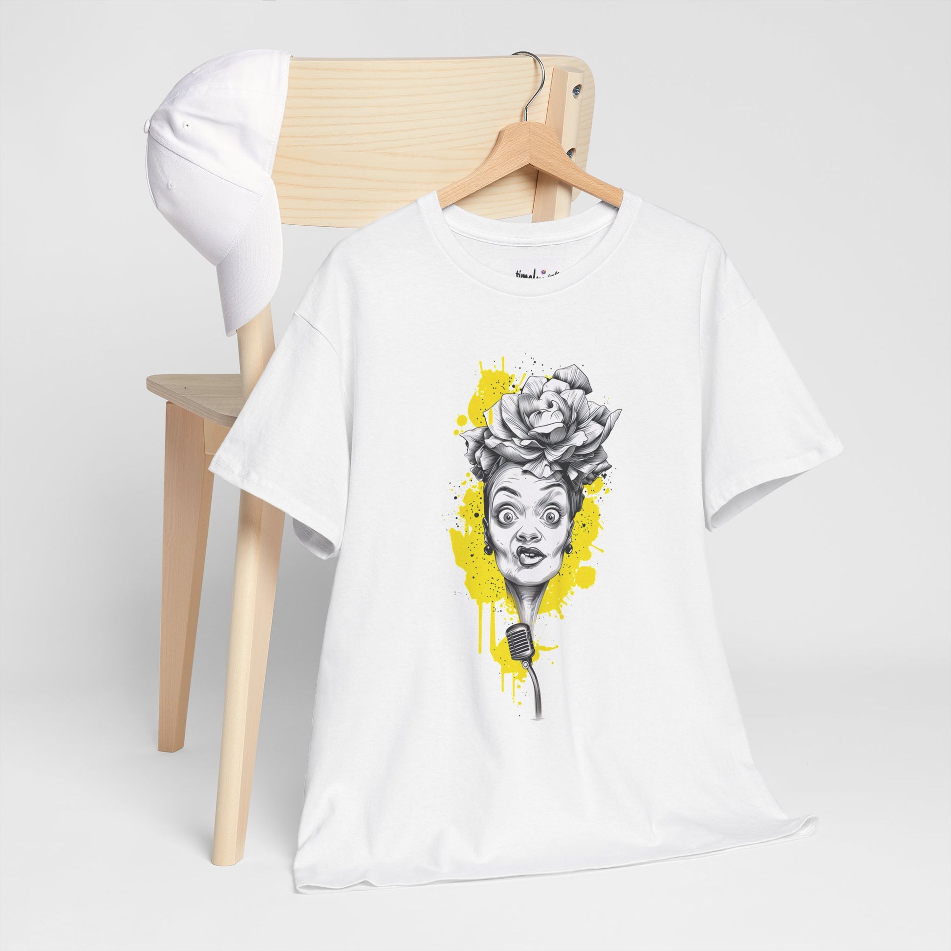 White t-shirt with a graphic design of a woman's face and flowers on a wooden chair.